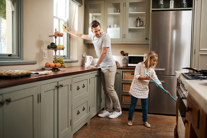 Shot of a young man and his daughter cleaning the kitchen at home